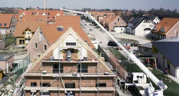 Böcker Autokran 35 /3000 schwenkt Schuttmulde über ein Haus